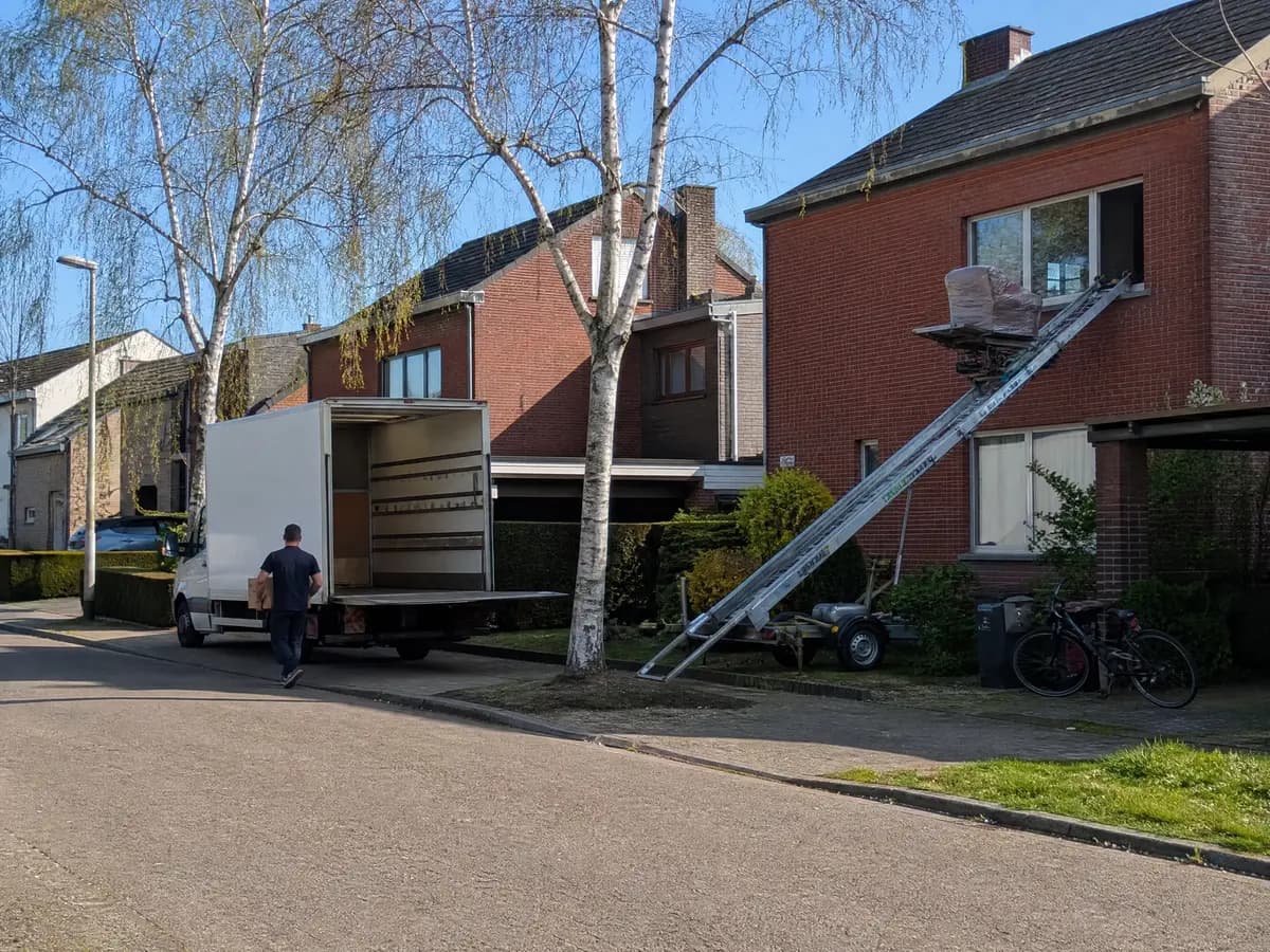Verhuisfirma Aartselaar: verhuiswagen op de oprit en ladderlift aan een woning in Aartselaar