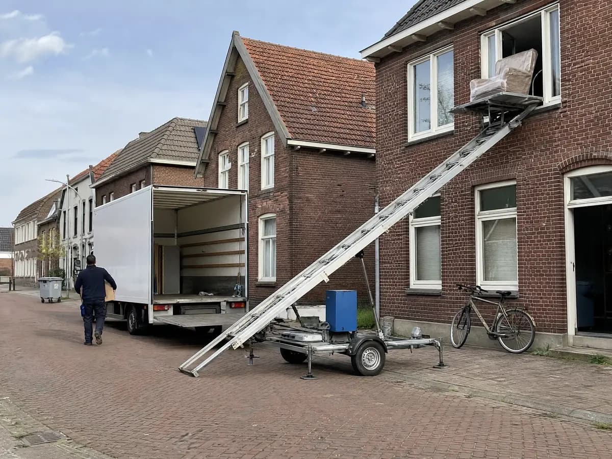 Verhuisfirma Baarle-Hertog: verhuiswagen op de oprit en ladderlift aan een woning in Baarle-Hertog