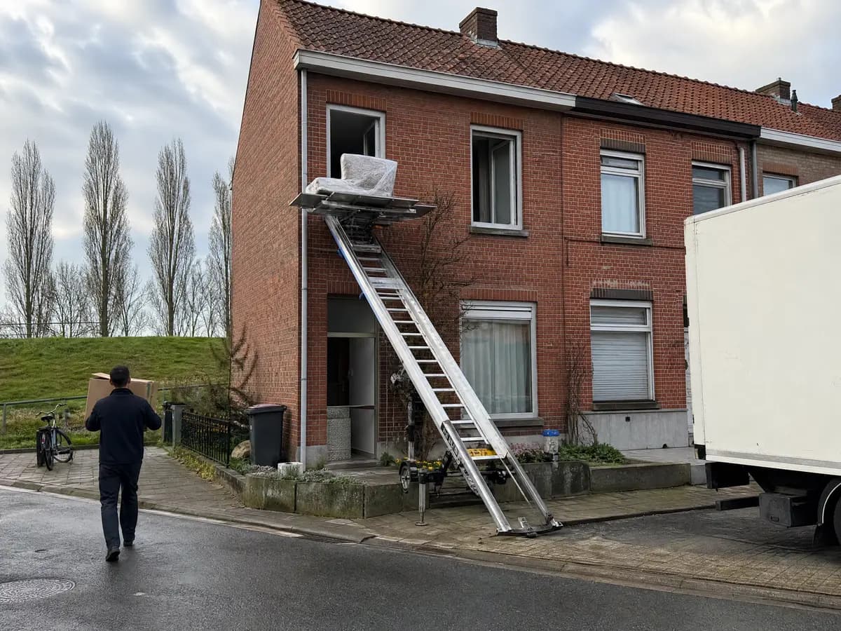 Verhuisfirma Beerse: ladderlift met meubels aan het raam van een woning in Beerse