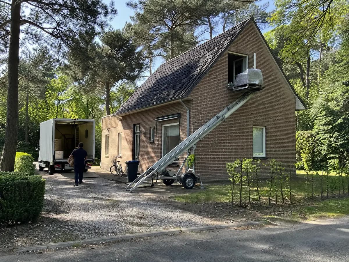 Verhuisfirma Bonheiden: verhuiswagen op de oprit en ladderlift aan een woning in Bonheiden