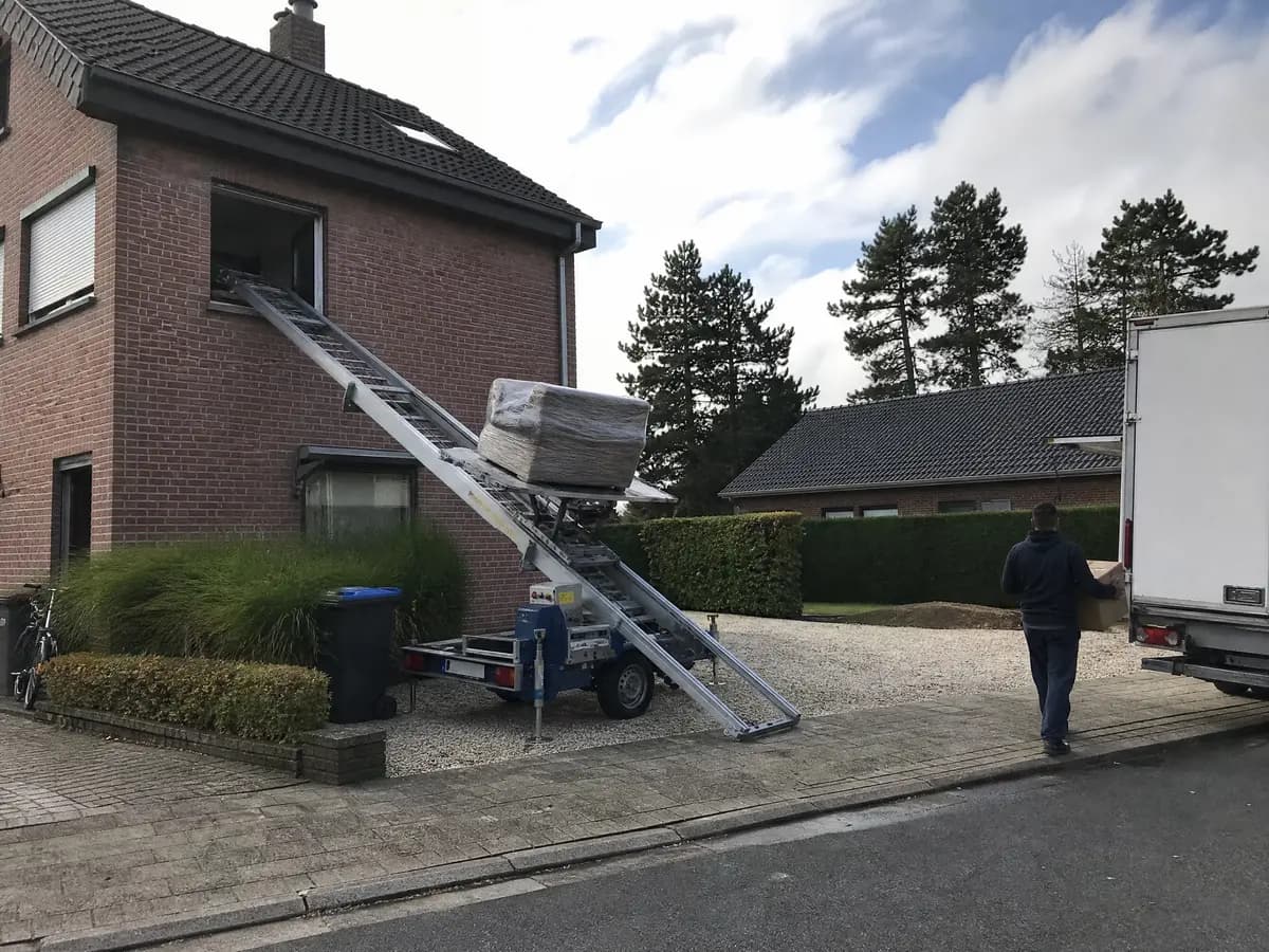 Verhuisfirma Essen: ladderlift met meubels aan het raam van een woning in Essen