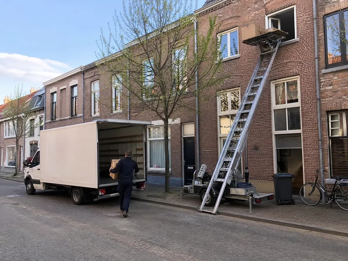 Verhuisfirma Geel: ladderlift aan de gevel en verhuiswagen voor een woning in Geel