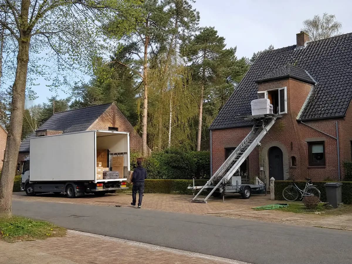 Verhuisfirma Grobbendonk: verhuiswagen op de oprit en ladderlift aan een woning in Grobbendonk