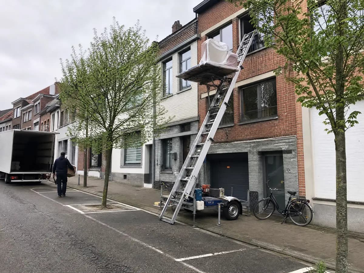 Verhuisfirma Heist-op-den-Berg: ladderlift met meubels aan het raam van een woning in Heist-op-den-Berg