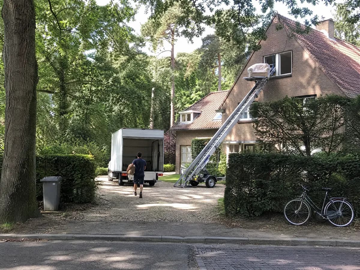 Verhuisfirma Kapellen: verhuiswagen op de oprit en ladderlift aan een woning in Kapellen