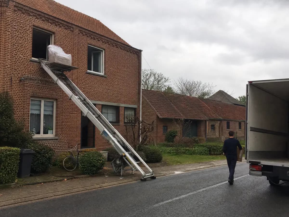 Verhuisfirma Laakdal: ladderlift met meubels aan het raam van een woning in Laakdal
