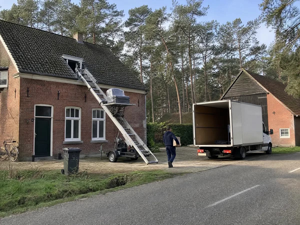Verhuisfirma Lille: verhuiswagen op de oprit en ladderlift aan een woning in Lille