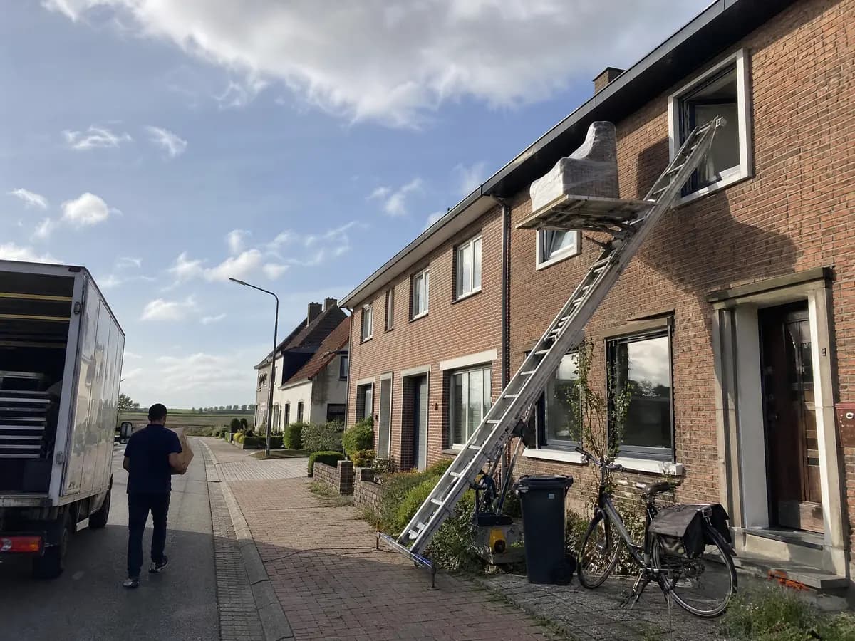 Verhuisfirma Lint: ladderlift met meubels aan het raam van een woning in Lint