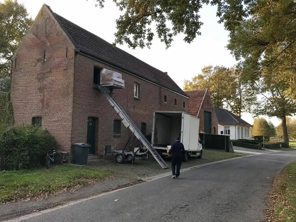 Verhuisfirma Merksplas: verhuiswagen op de oprit en ladderlift aan een woning in Merksplas