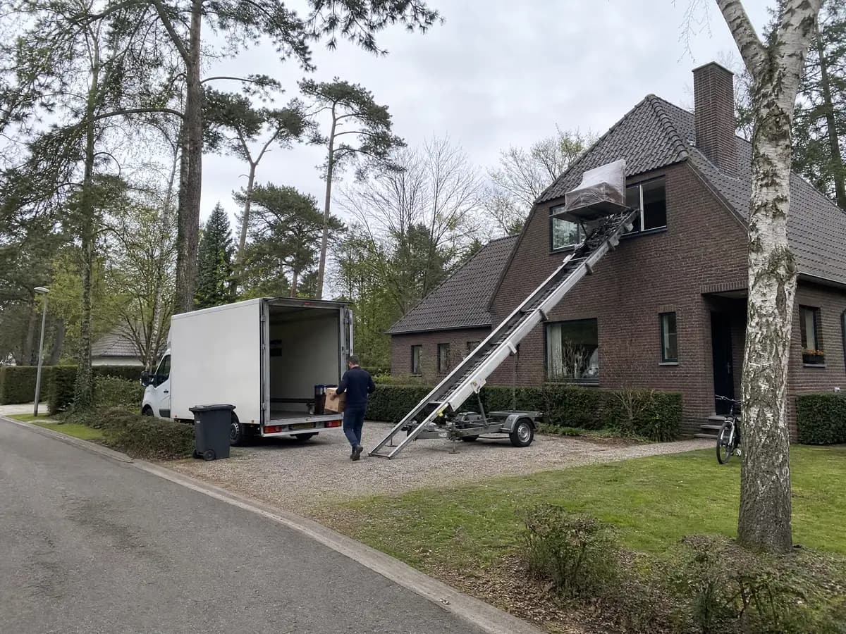 Verhuisfirma Oud-Turnhout: verhuiswagen op de oprit en ladderlift aan een woning in Oud-Turnhout