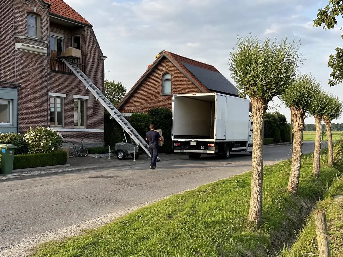 Verhuisfirma Puurs-Sint-Amands: ladderlift aan de gevel en verhuiswagen voor een woning in Puurs-Sint-Amands