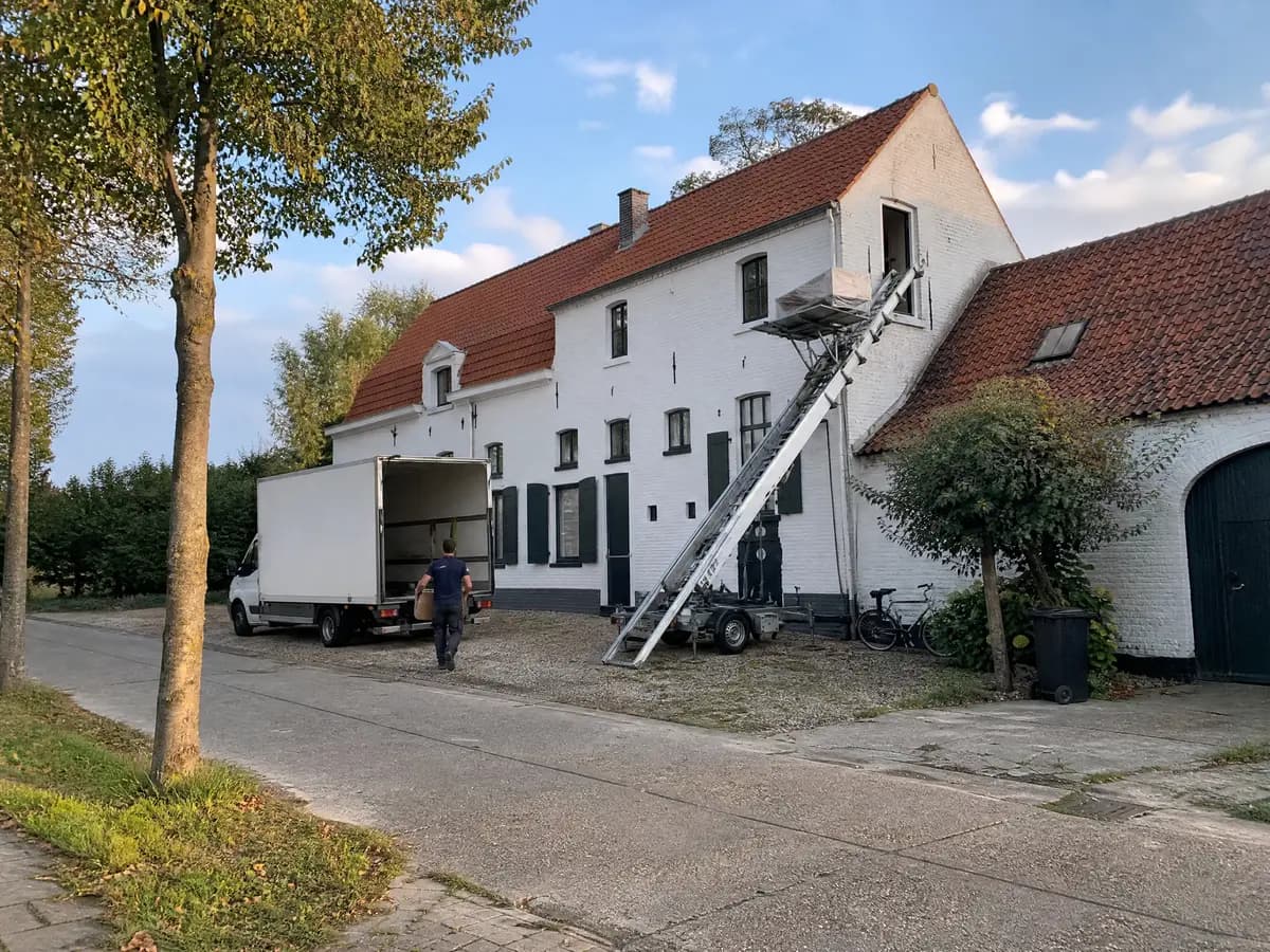 Verhuisfirma Ranst: verhuiswagen op de oprit en ladderlift aan een woning in Ranst