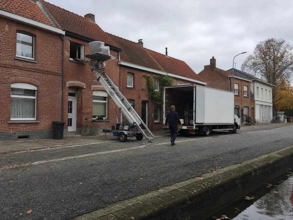Verhuisfirma Rijkevorsel: verhuiswagen op de oprit en ladderlift aan een woning in Rijkevorsel