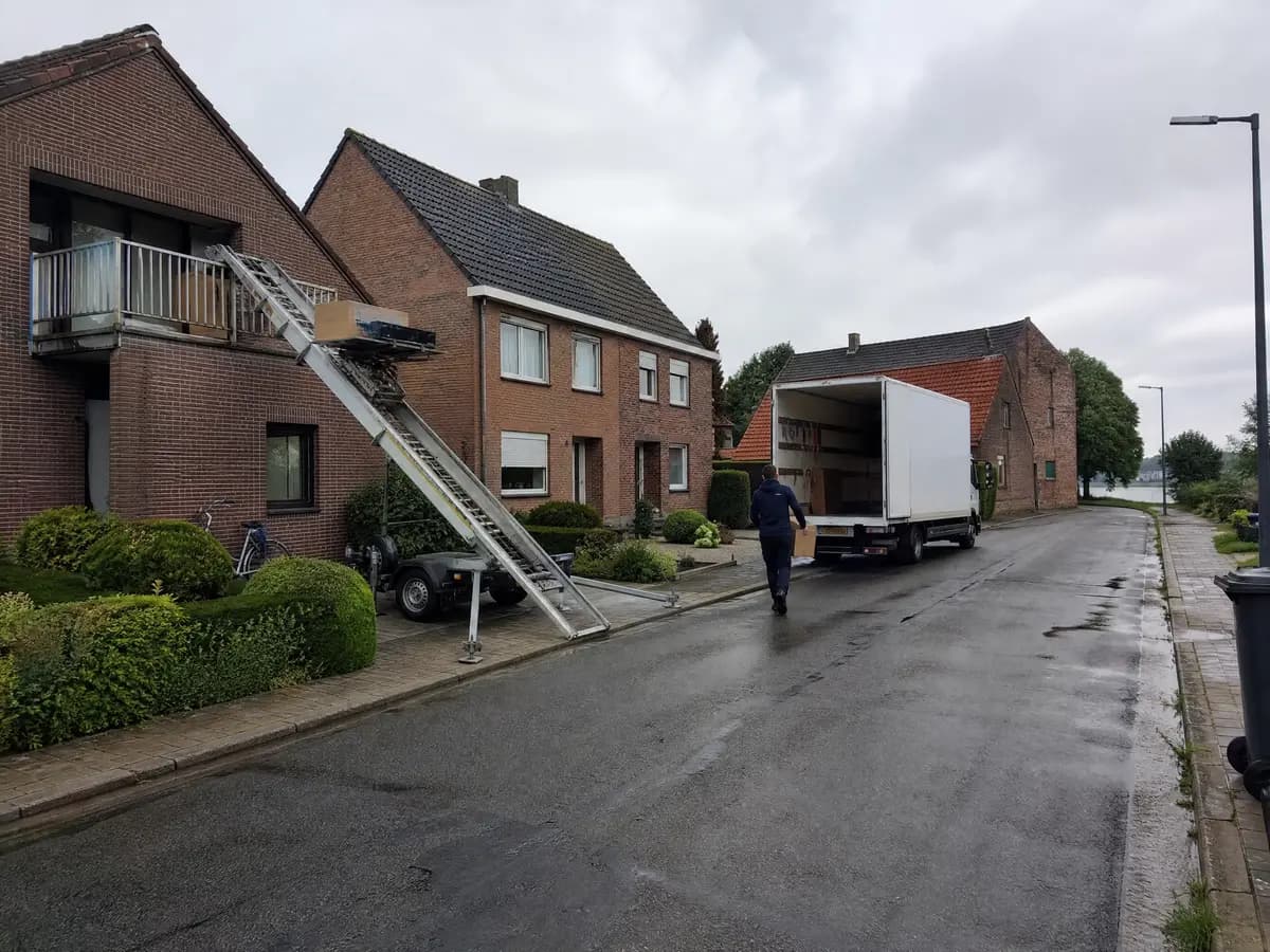 Verhuisfirma Schelle: ladderlift aan de gevel en verhuiswagen voor een woning in Schelle
