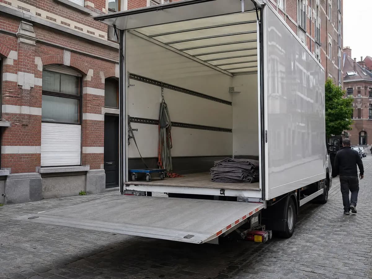Lege laadruimte van een verhuiswagen met laadklep, verhuisdekens en spanbanden