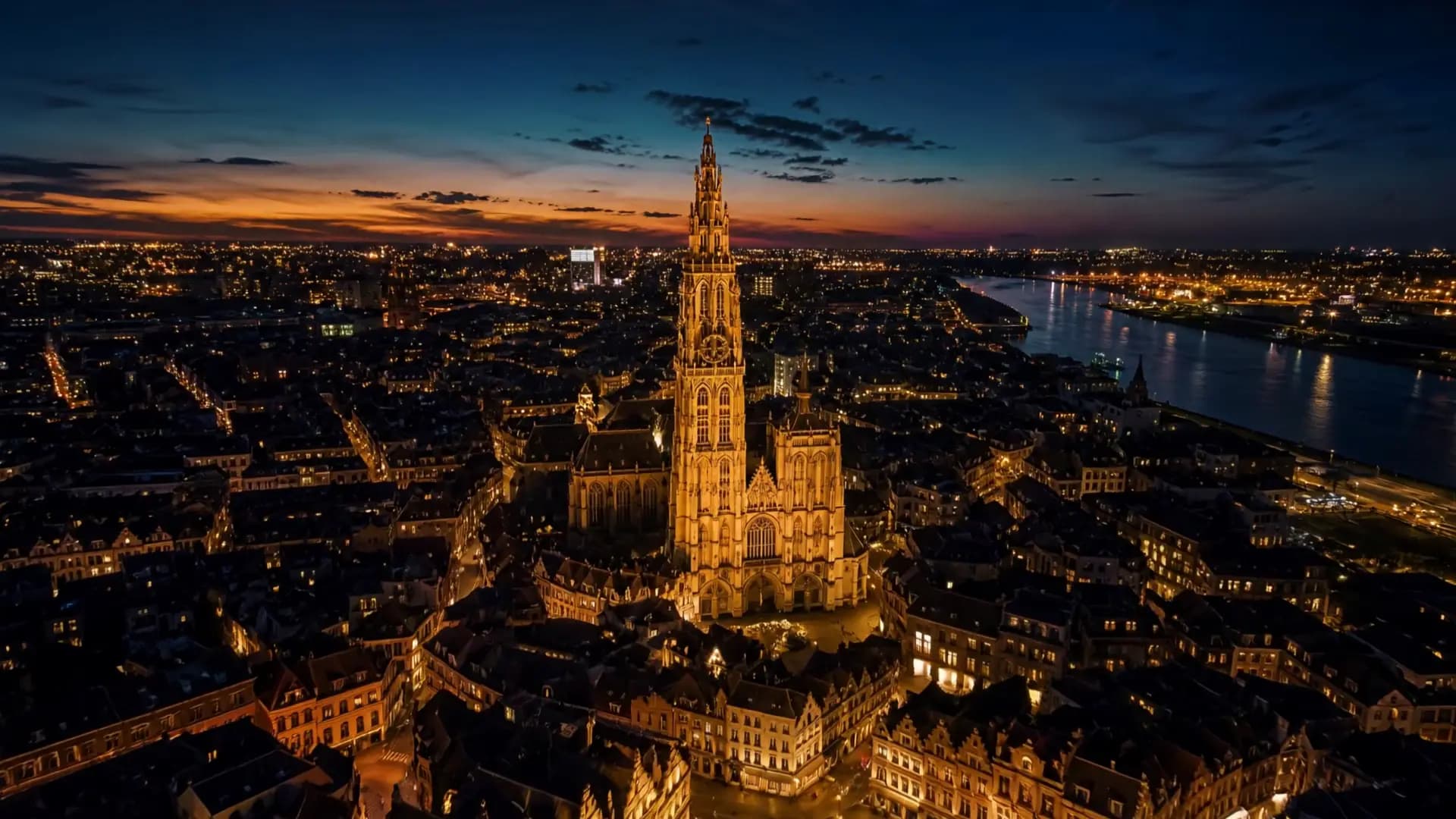De kathedraal van Antwerpen bij valavond, met de verlichte binnenstad