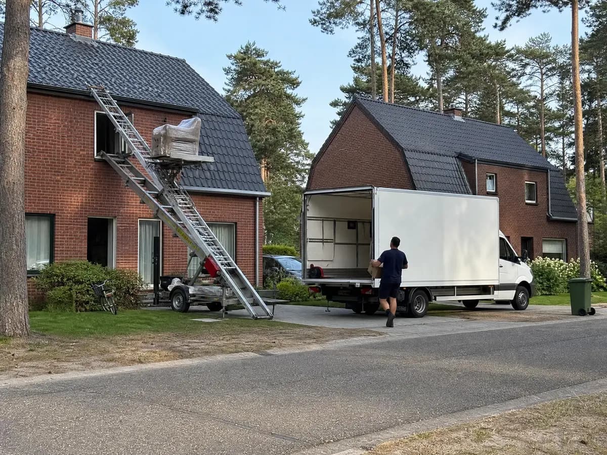 Verhuisfirma Dessel: verhuiswagen op de oprit en ladderlift aan een woning in Dessel