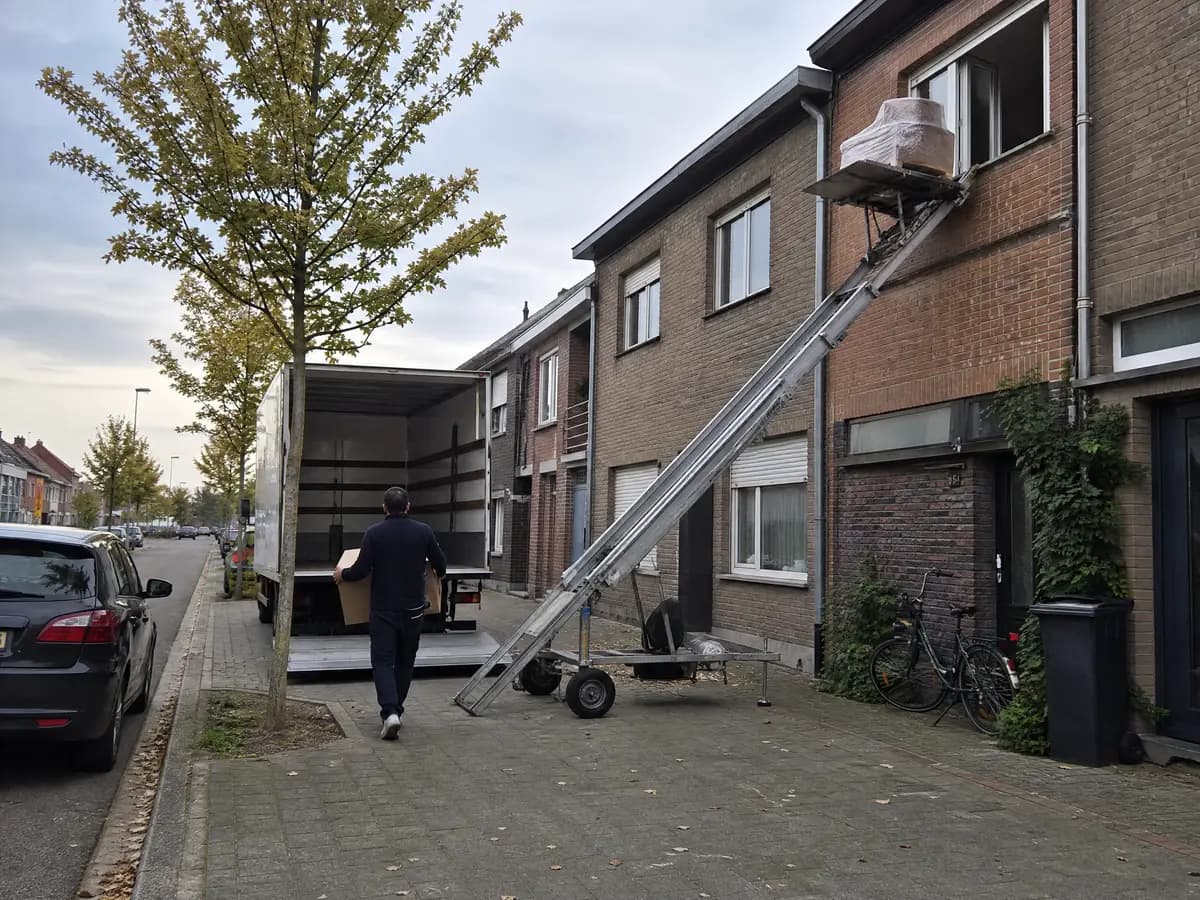 Verhuisfirma Wommelgem: ladderlift aan de gevel en verhuiswagen voor een woning in Wommelgem