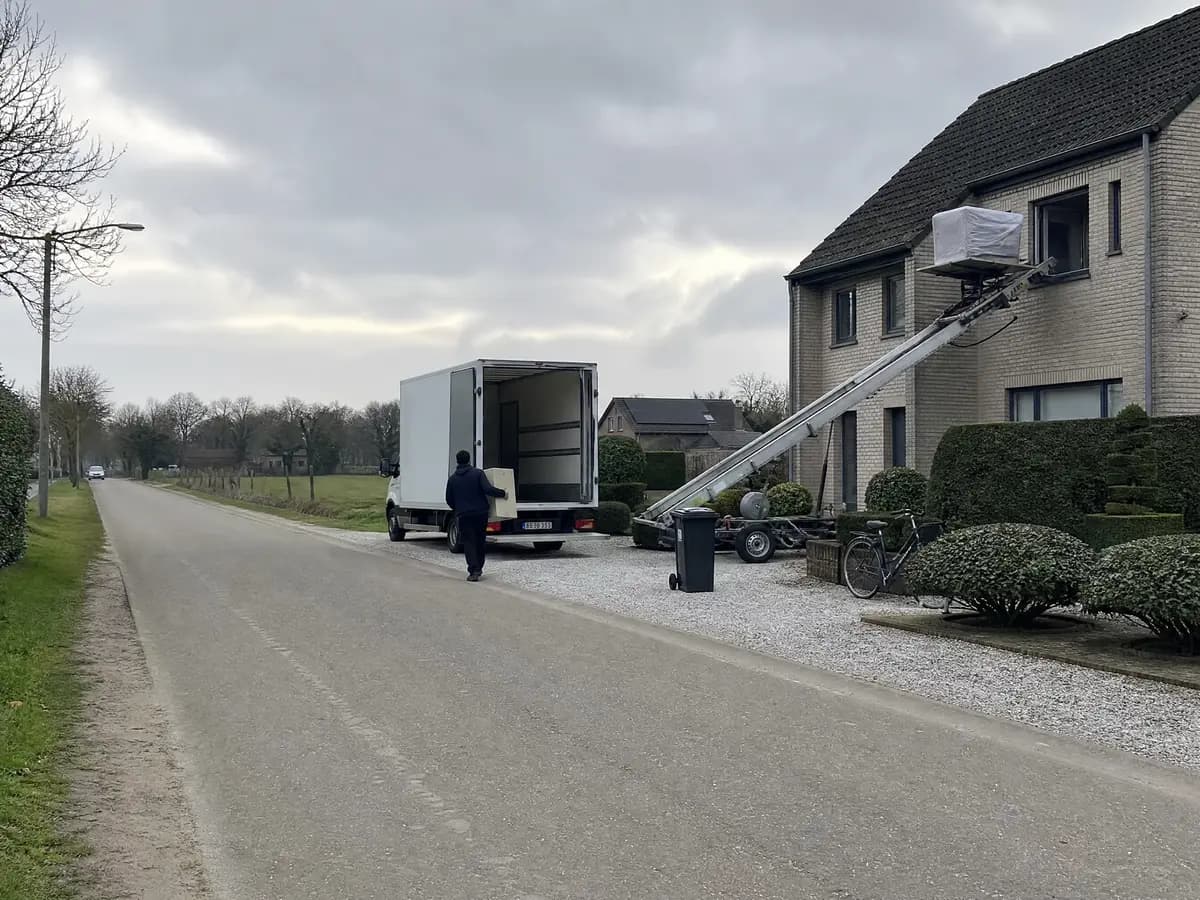 Verhuisfirma Wuustwezel: verhuiswagen op de oprit en ladderlift aan een woning in Wuustwezel