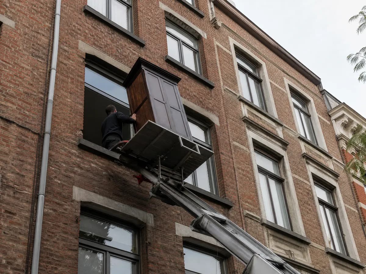 Een kast komt via de ladderlift door het raam naar beneden langs een Antwerpse gevel
