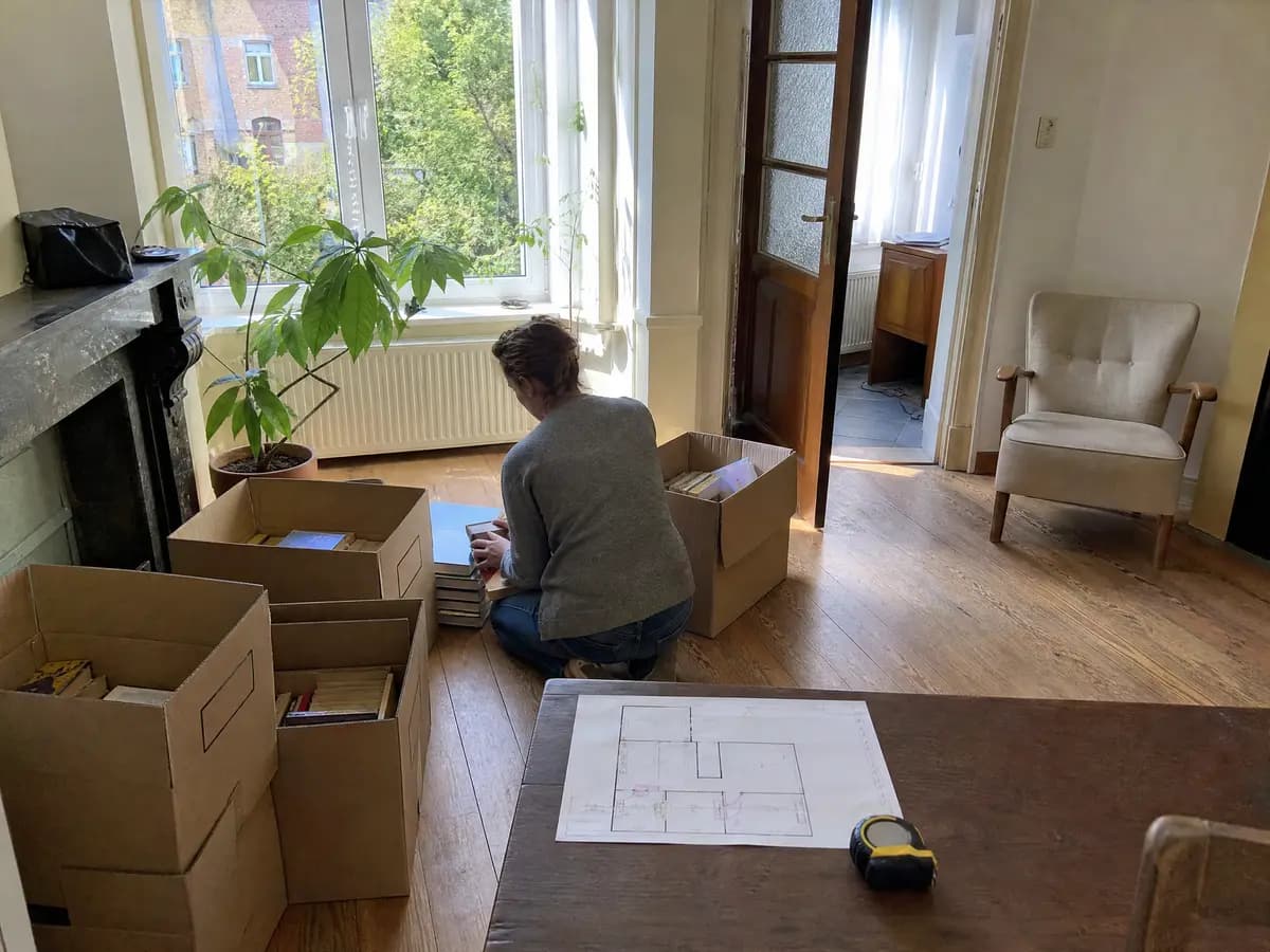 Spullen sorteren in dozen met een plattegrond bij een verhuis naar een kleiner huis