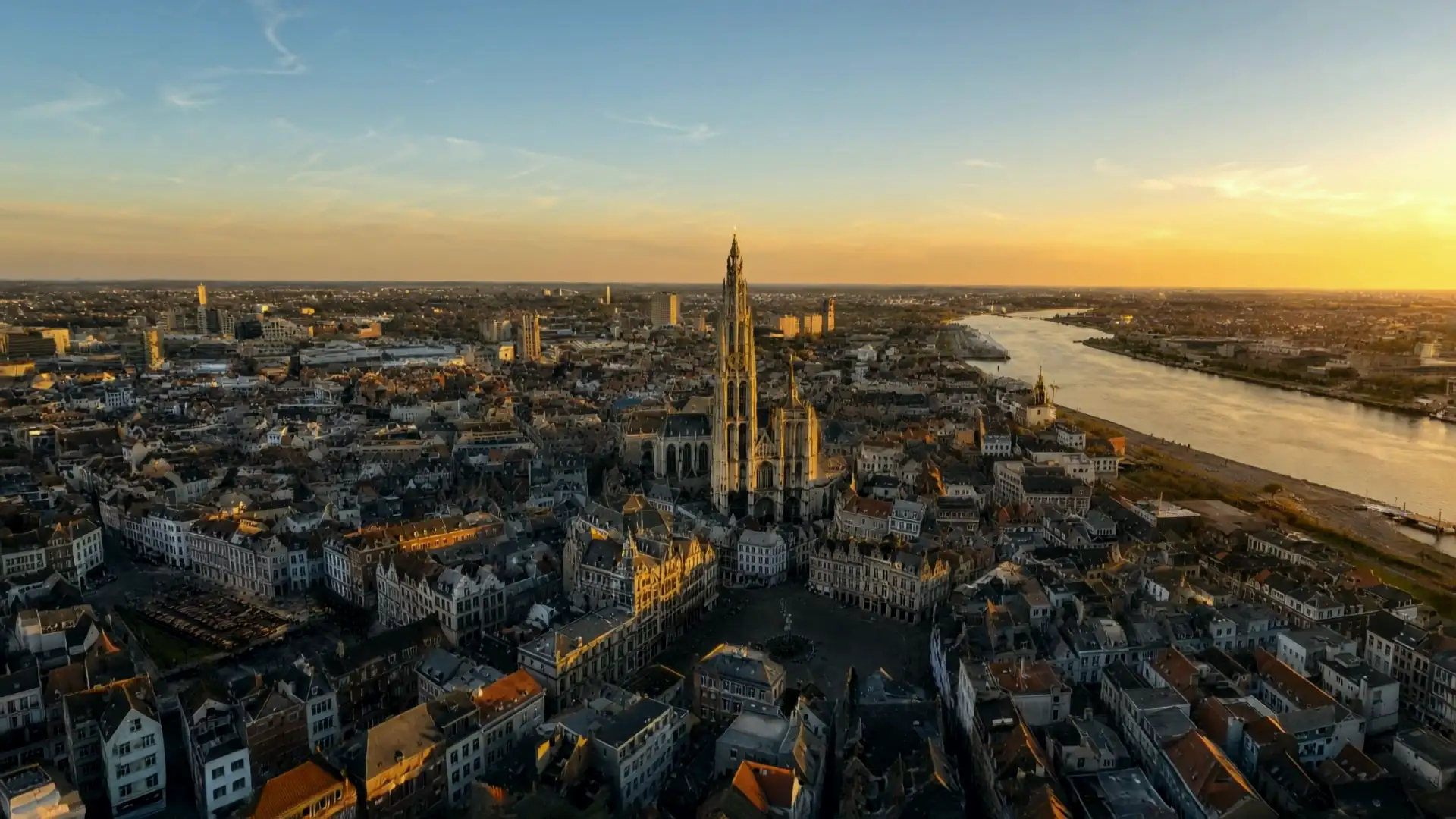 Antwerpen vanuit de lucht bij zonsondergang: de kathedraal achter de Grote Markt en rechts de Schelde