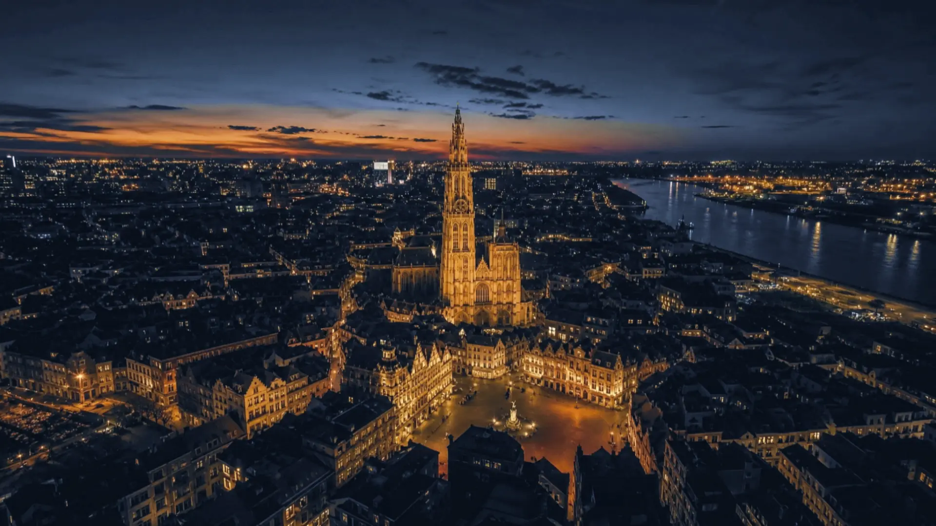 Antwerpen vanuit de lucht bij valavond met de verlichte kathedraal en de Schelde