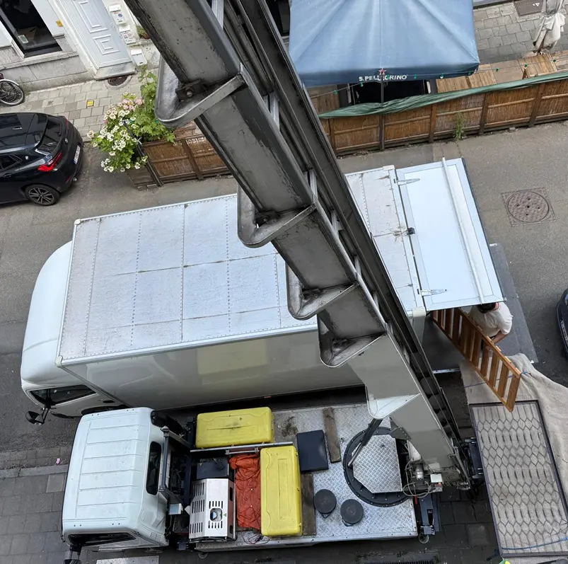 Verhuislift op vrachtwagen tijdens verhuizing, bovenaanzicht van laadproces